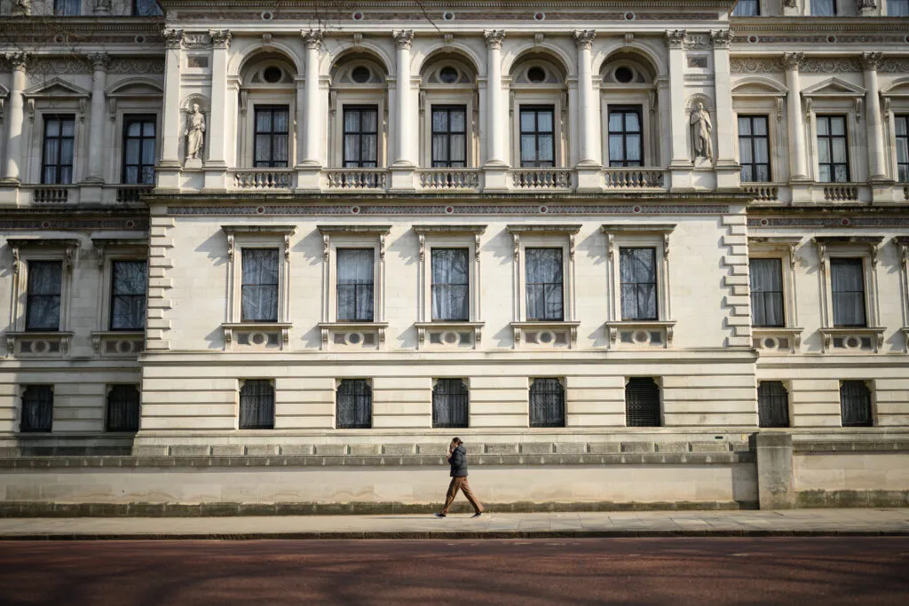Une personne passe devant le bâtiment du Foreign Office à Londres le 24 mars 2025