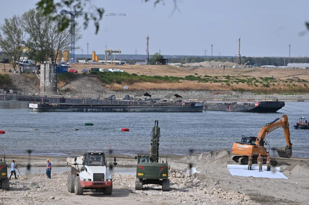 Travailleurs et machines sur les berges du Danube près de la centrale de Paks le 18 août 2026